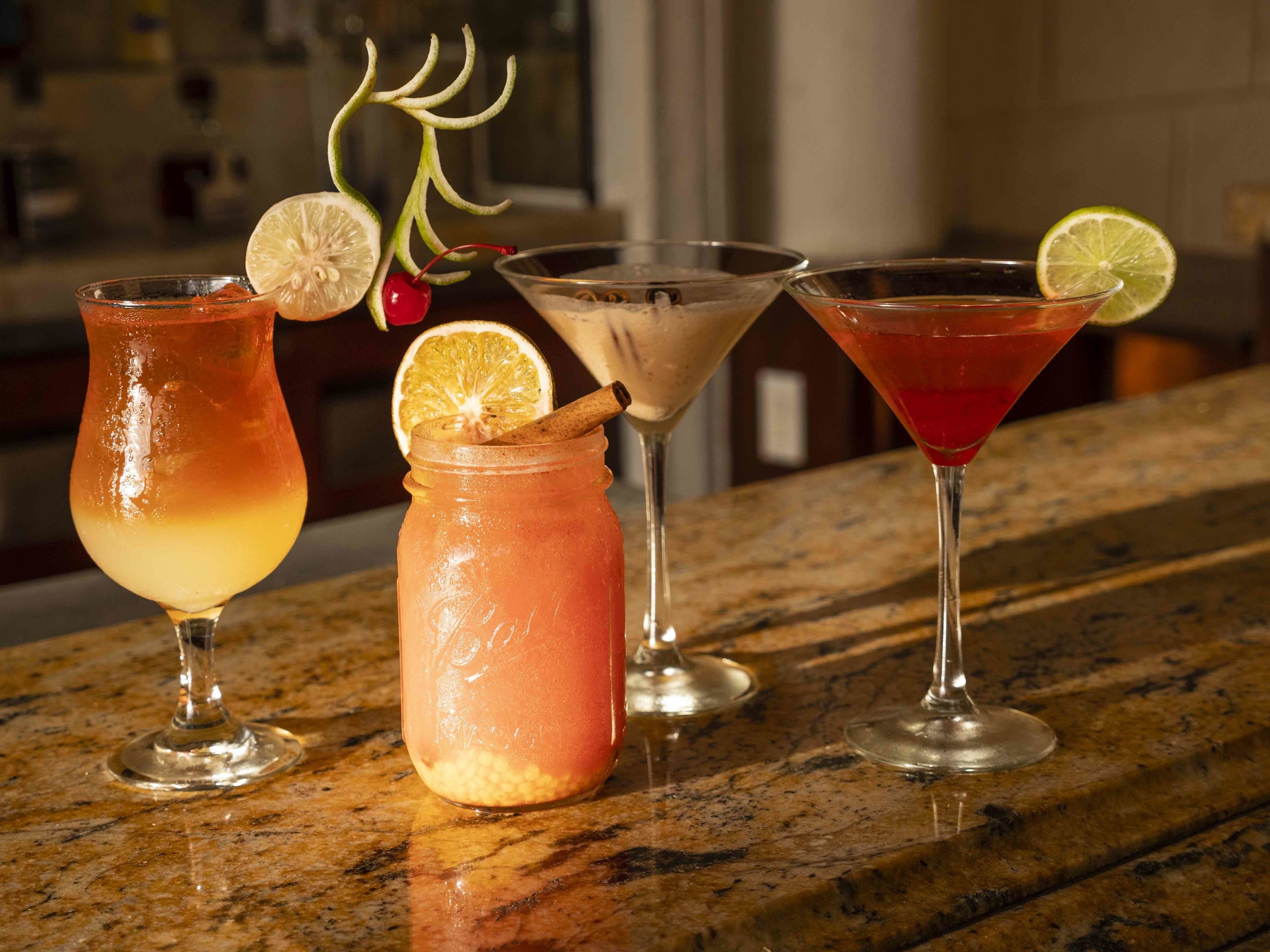 Three different drinks on a marble countertop.