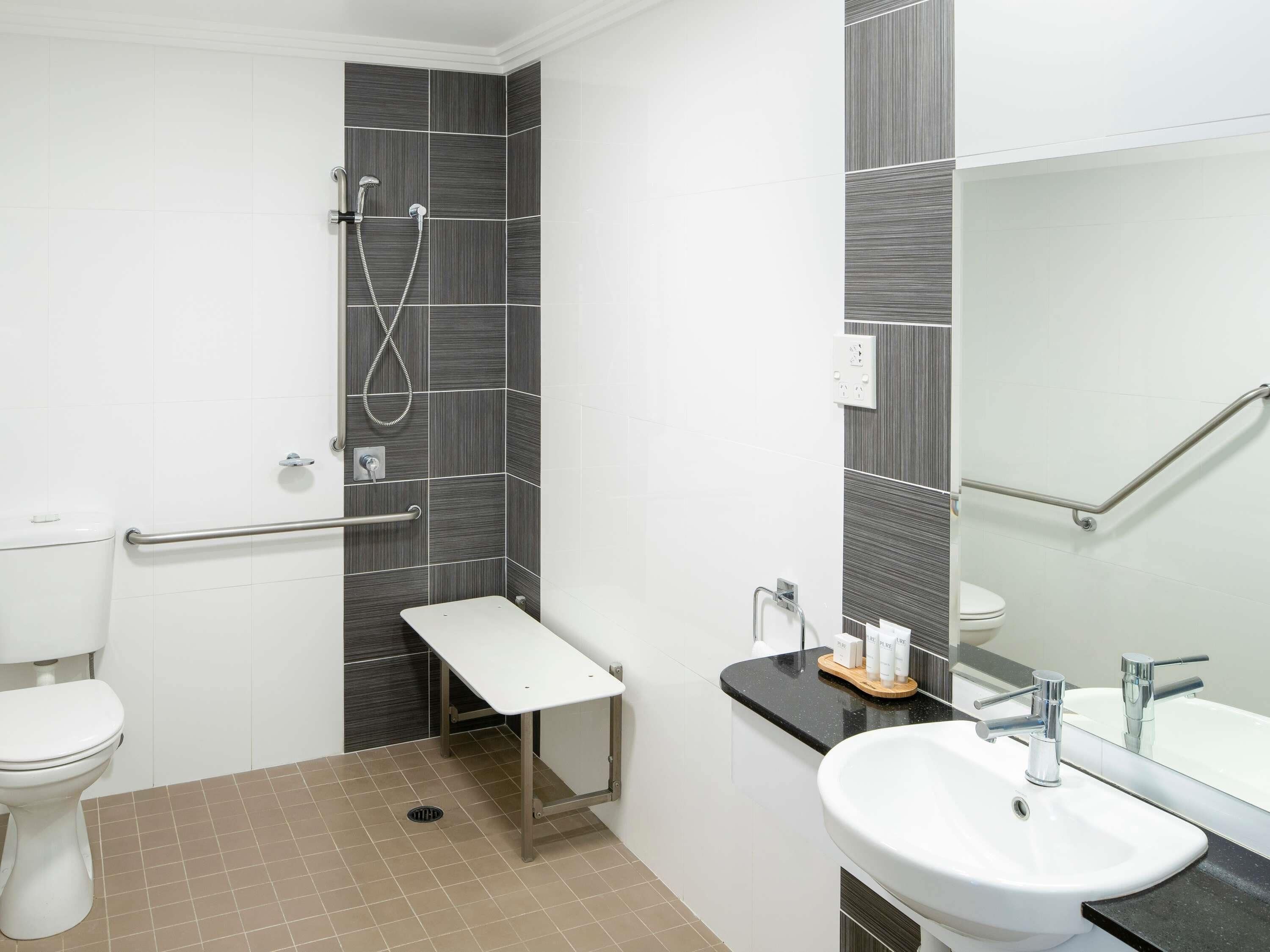 Un baño moderno con ducha, inodoro y lavamanos.