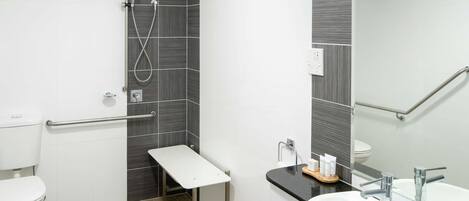 Un baño moderno con ducha, inodoro y lavamanos.
