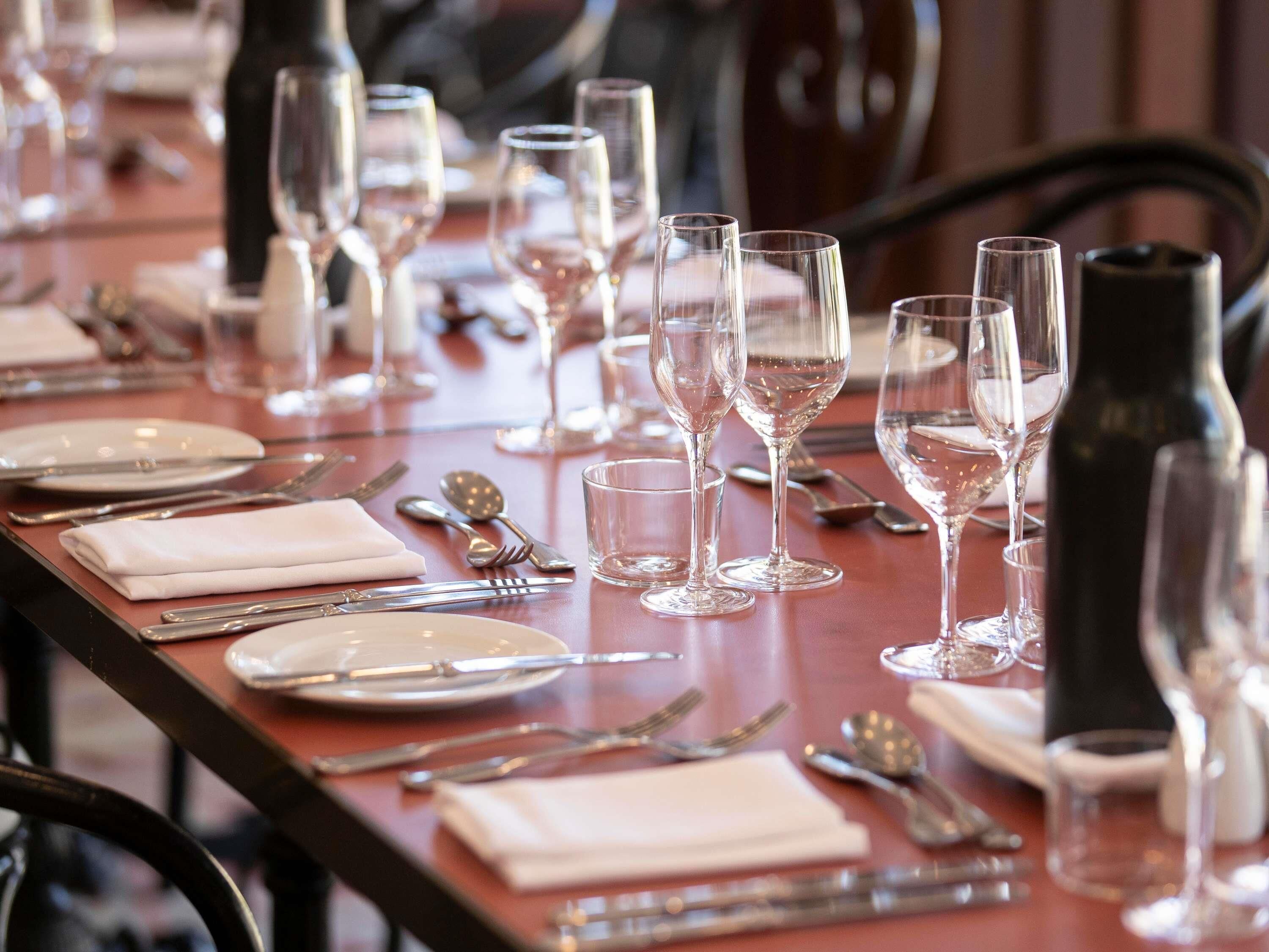 A dining table set with multiple wine glasses, plates, and cutlery.