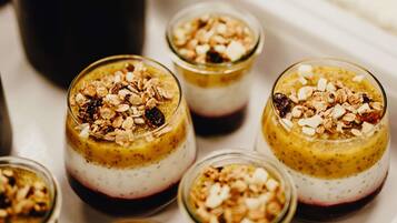 Una bandeja con seis vasos de vidrio para postre, cubiertos de granola y fruta seca.