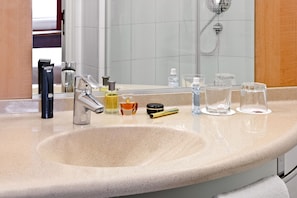 Bathroom features a large sink, shower, and hairdryer.