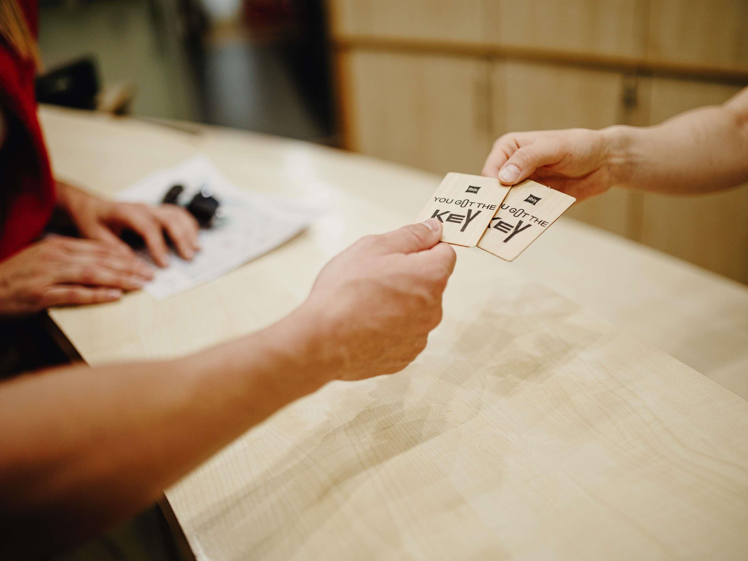 Two hands exchanging a card with the text 'YOU GOT THE KEY' on it.