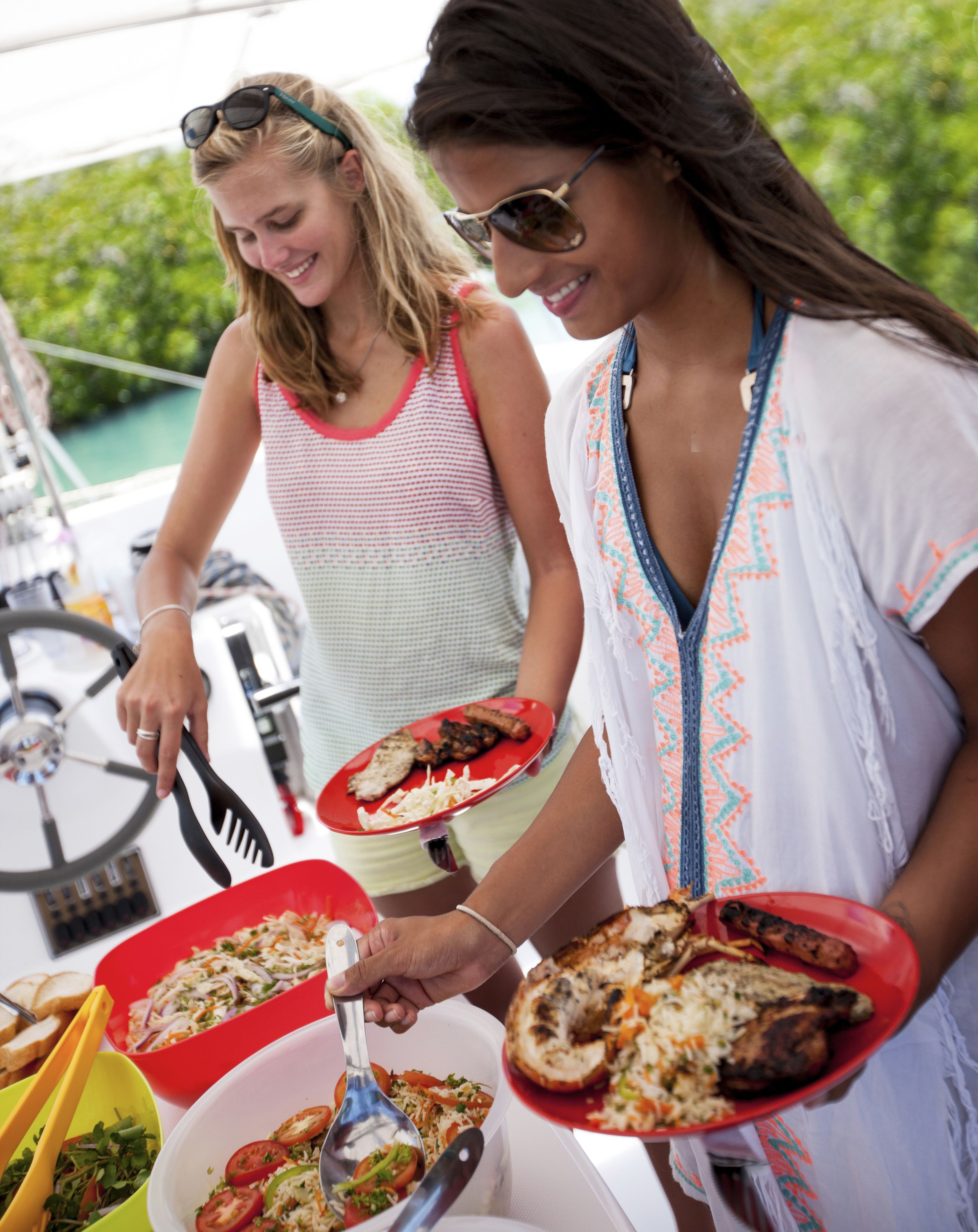 Two people serving food on a boat.