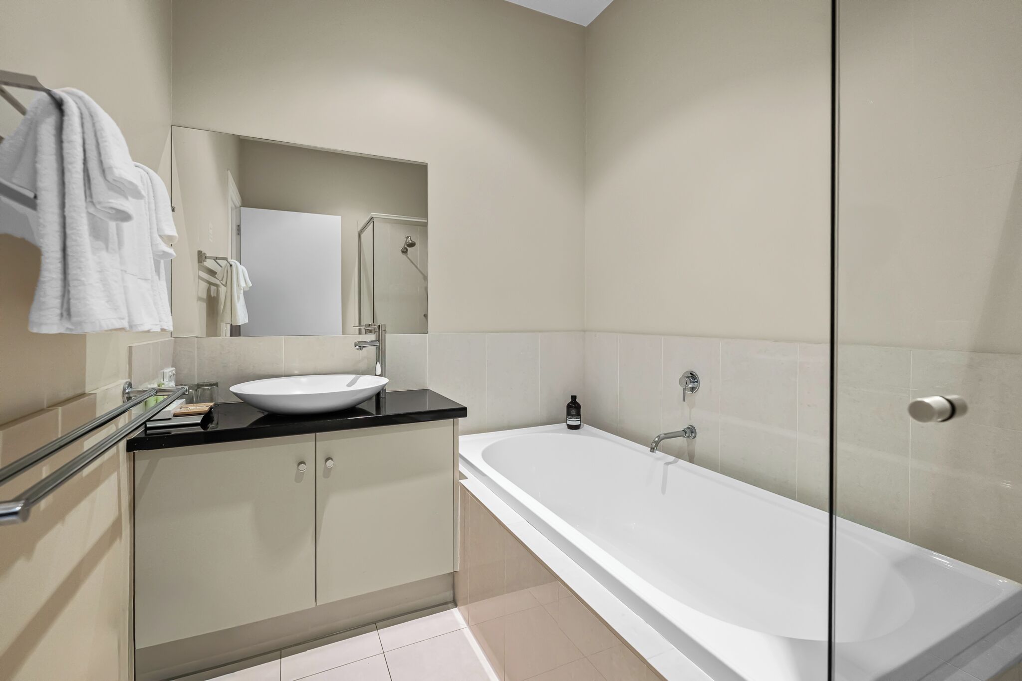 Un bagno moderno con una vasca da bagno ampia, un lavandino e un box doccia in vetro.