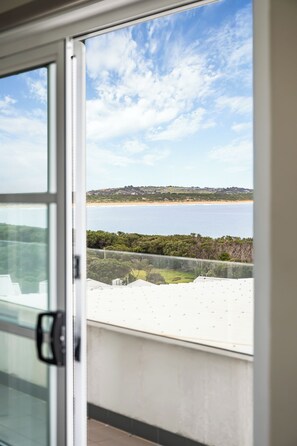 A view from a balcony with a clear sky, a beach, and a distant hill. - Deep Blue Hotel & Hot Springs (Warrnambool)