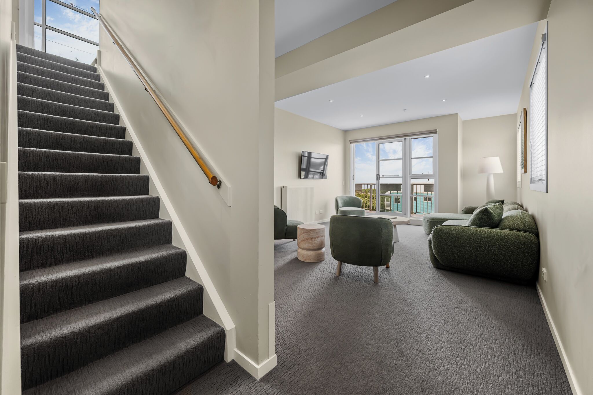 A staircase leading to a living area with a view of the outdoors.