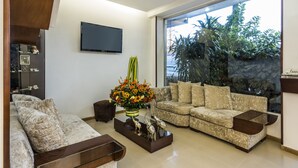 Una sala de estar moderna con un sofá, una mesa de centro y un televisor de pantalla plana montado en la pared.