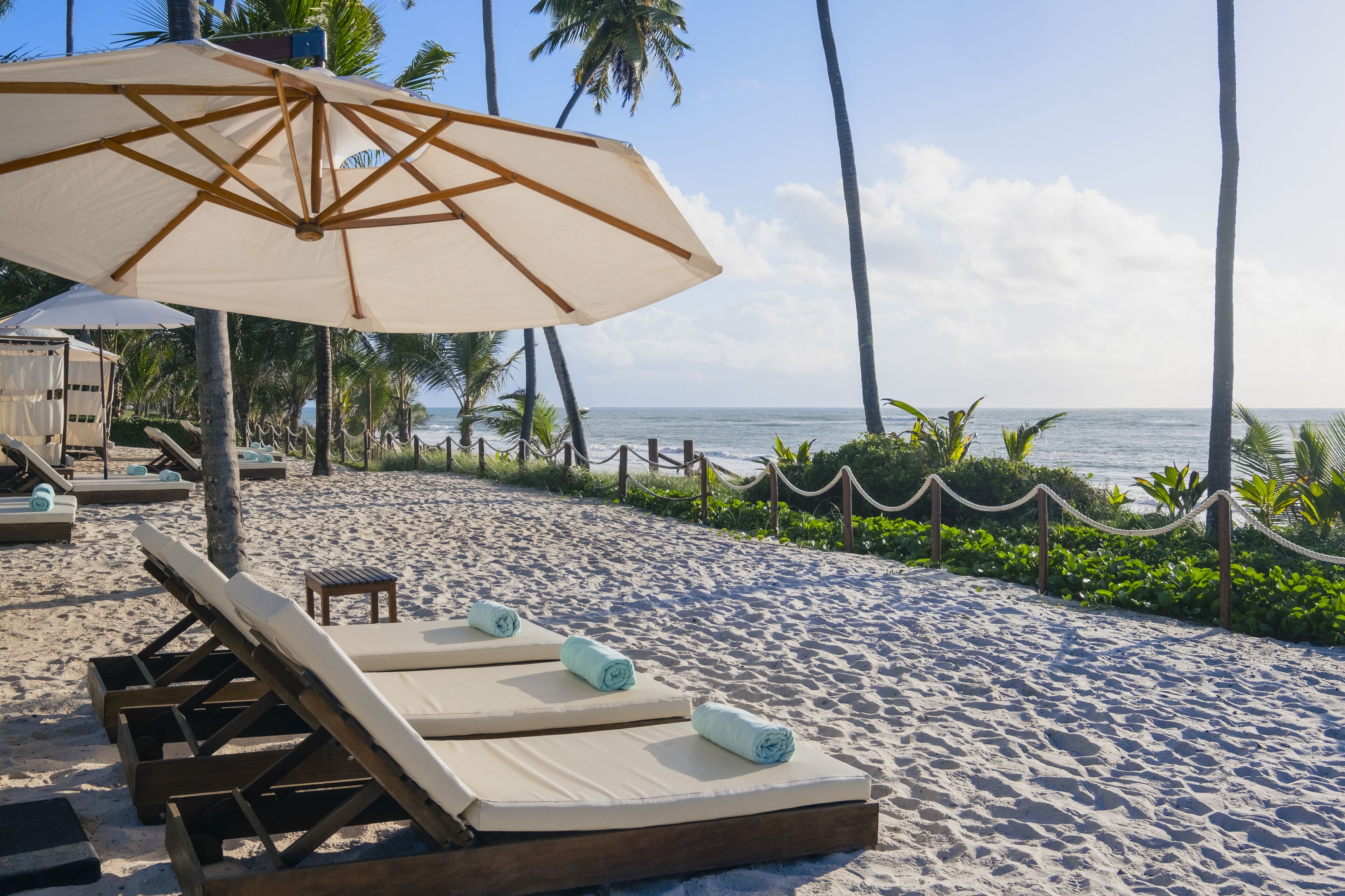 Rannalla, aurinkotuoleja, rantalentopallomahdollisuus