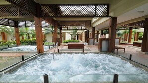 A spa area with a hot tub, wooden pillars, and a tiled floor. - Iberostar Waves Bahia - All Inclusive (Mata de São João)