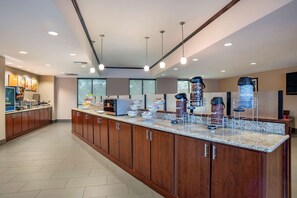A modern kitchen with wooden cabinets, granite countertops, and various appliances. - Comfort Suites Mobile (Mobile)