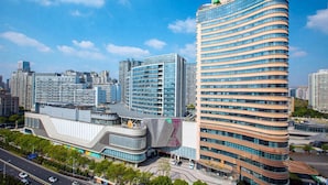 A modern hotel with a curved facade, multiple floors, and a prominent sign at the top. - Holiday Inn Hangzhou Xiaoshan by IHG (Hangzhou)