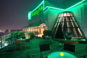 A Holiday Inn with a rooftop terrace featuring outdoor seating and a glass pyramid structure. - Holiday Inn Hangzhou Xiaoshan by IHG (Hangzhou)