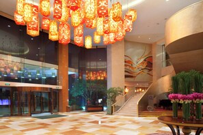 A spacious lobby with a checkered floor, a staircase, and a reception desk. - Holiday Inn Hangzhou Xiaoshan by IHG (Hangzhou)