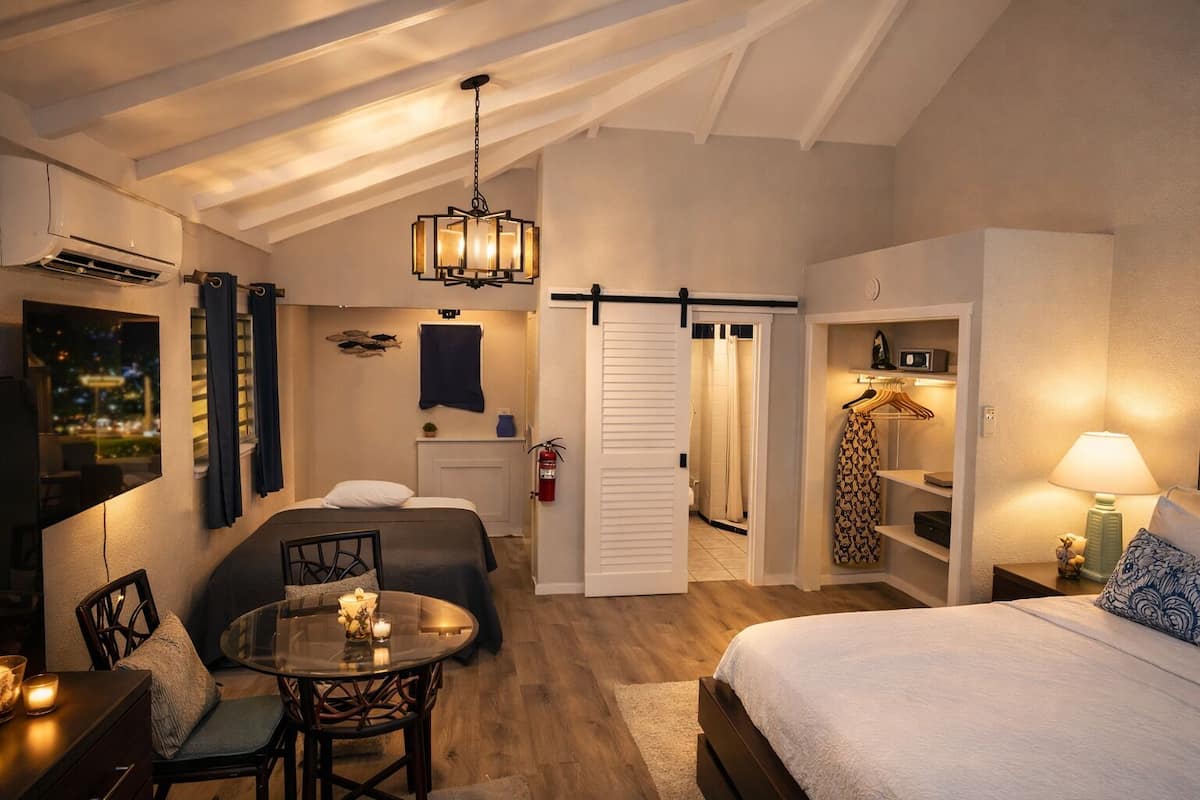 Une chambre à coucher avec un lit, une table de chevet, une lampe et une vue sur la ville la nuit.