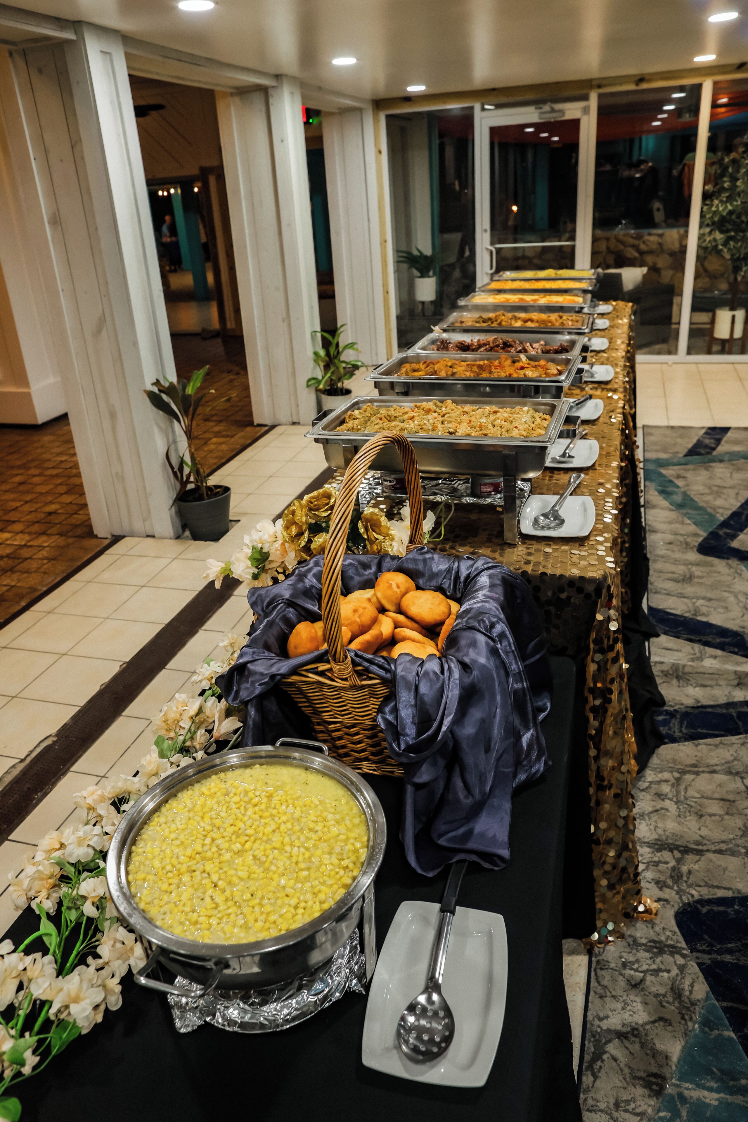 A buffet setup with various food items and a large bowl of lentils.