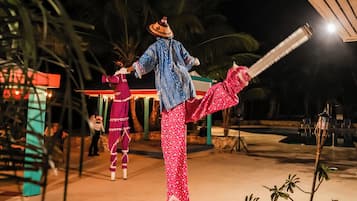 A nighttime outdoor scene with a person in traditional attire performing a dance.