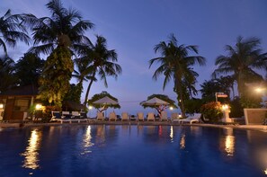 Alberca al aire libre y camastros 