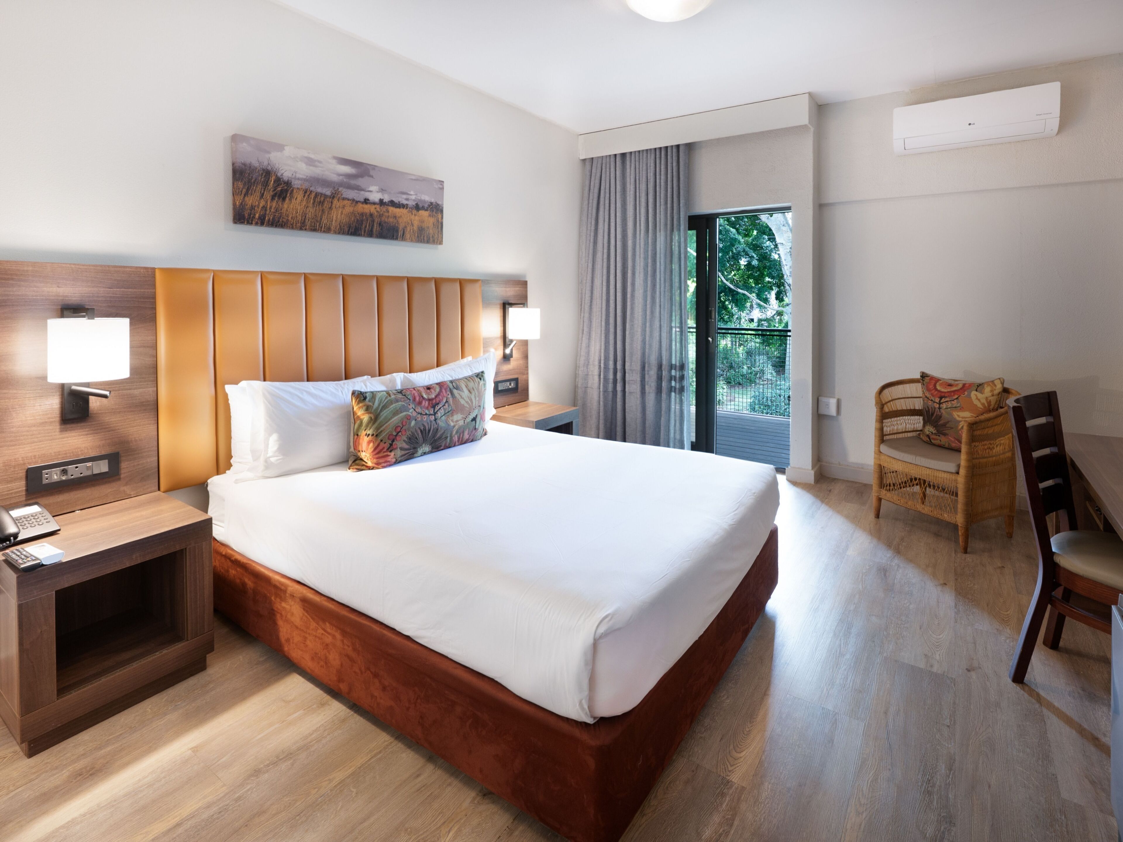 Une chambre d’hôtel avec un grand lit, des lampes de chevet, un bureau et une chaise.
