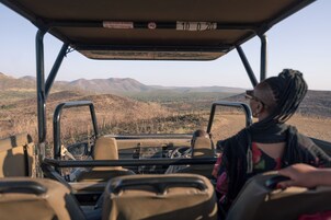 Interior de vehículo con volante, tablero de control y vista de un paisaje montañoso a través del parabrisas.