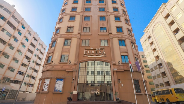 Un hotel de varios pisos con una entrada llamativa y un letrero que dice 'Eureka'.