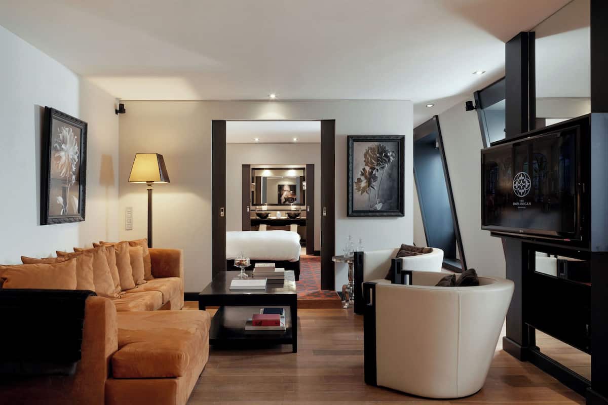 Un salon moderne avec un canapé, une table basse, un téléviseur et des œuvres d’art accrochées aux murs.