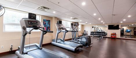 A gym with treadmills, elliptical machines, and weight equipment.