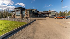 A building with 'PRESTIGE' signage, a parking lot, and a statue. - Prestige Prince George Lodge (Prince George)