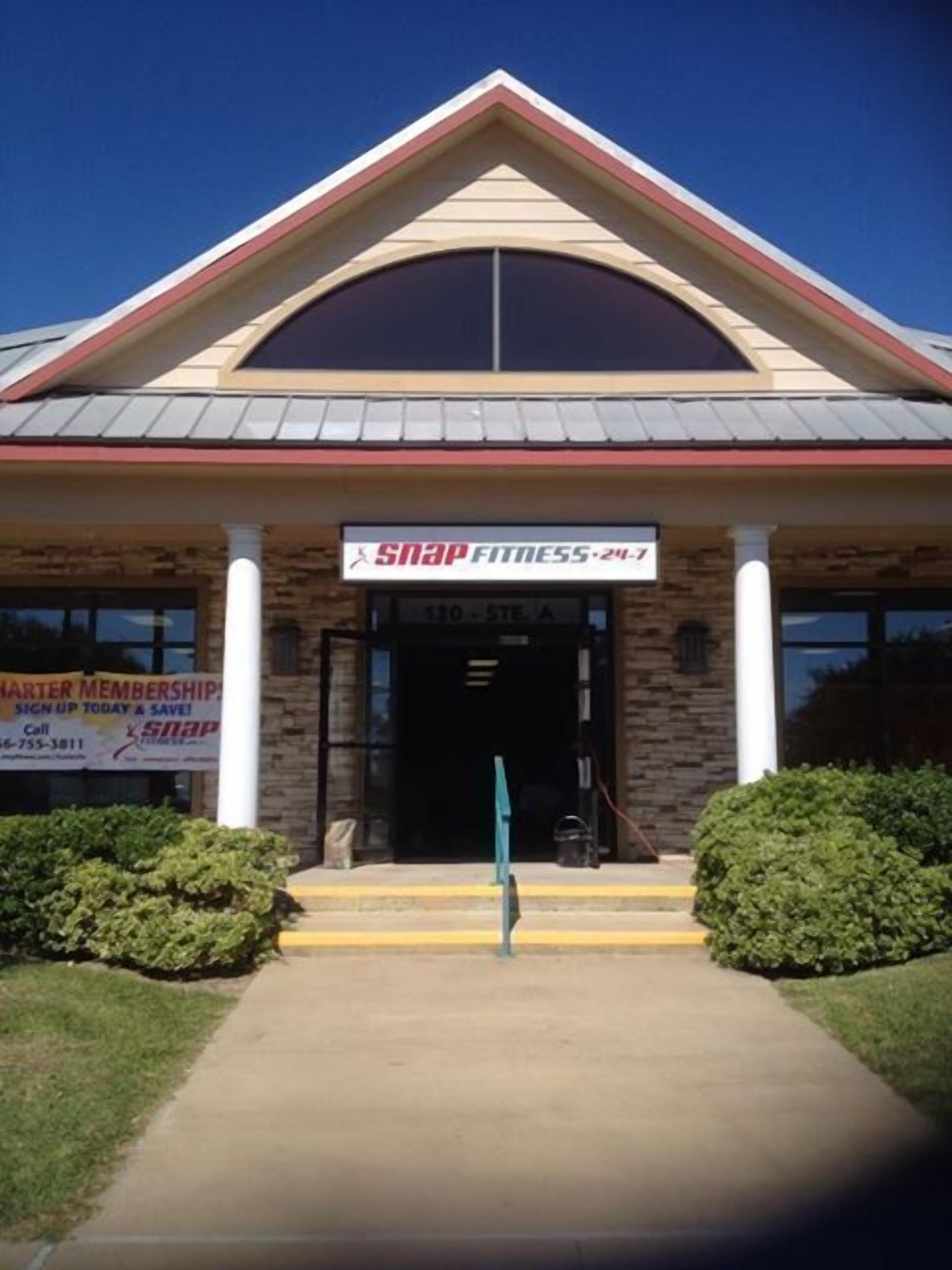 A building with a sign reading "Snap Fitness 207".