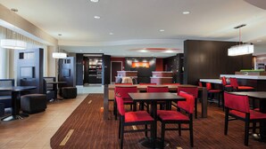 A modern hotel lobby with a reception desk, seating area, and a TV screen. - Courtyard by Marriott Corpus Christi (Corpus Christi)