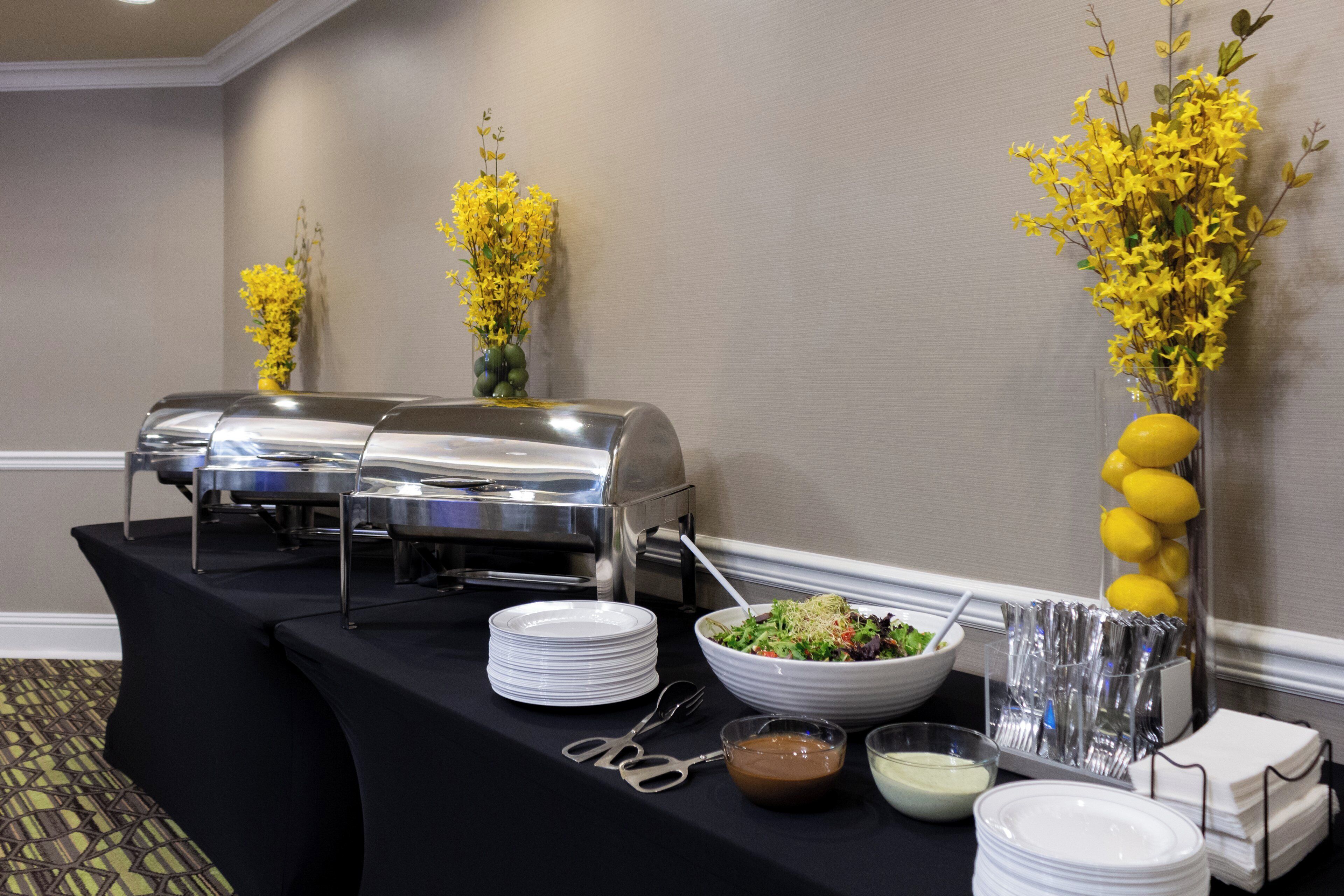 A buffet setup with a table, salad bowl, and condiments.