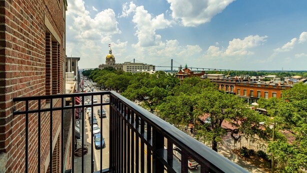 Een balkon met uitzicht op een stadsgezicht, inclusief gebouwen en een brug.
