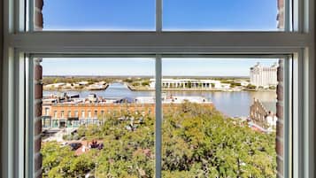 A view through a window of a riverside area with buildings, a bridge, and a large hotel.