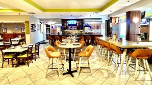 A restaurant with multiple tables and chairs, a bar area, and a counter.