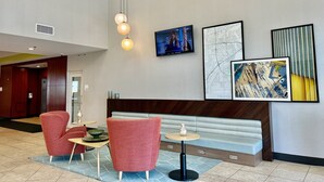 A lobby with a reception desk, seating area, and artwork on the walls.