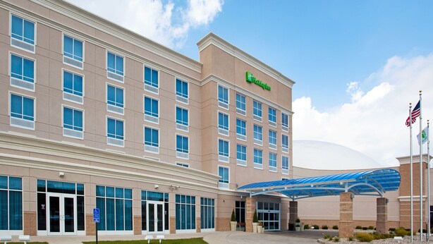 A large hotel building with a prominent 'Holiday Inn' sign, multiple windows, and a covered entrance area.