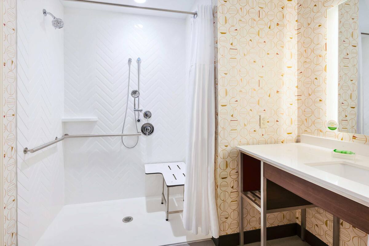 A bathroom with a shower, toilet, and sink.