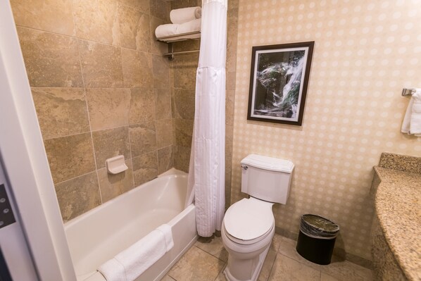 A bathroom with a bathtub, toilet, and a shower curtain. - Hilton Garden Inn Bowling Green (Bowling Green)