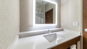 A bathroom with a white sink, a mirror, and a shower visible in the background. - Holiday Inn Express & Suites Fort Worth - Fossil Creek by IHG (Fort Worth)