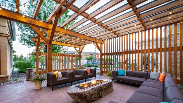 An outdoor patio with wooden pergola, seating area, and a fire feature. - Hilton Garden Inn Billings (Billings)