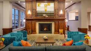 A spacious living area with a fireplace, multiple seating options, and large windows. - Hilton Garden Inn Billings (Billings)