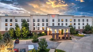 A Hampton Inn hotel with a central courtyard, multiple floors, and a parking area.
