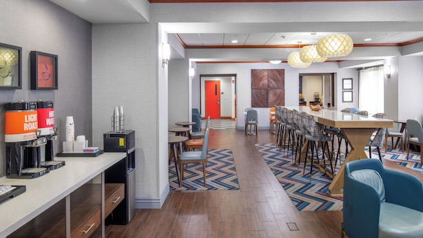 A hotel lobby with a reception desk, seating area, and a conference room.