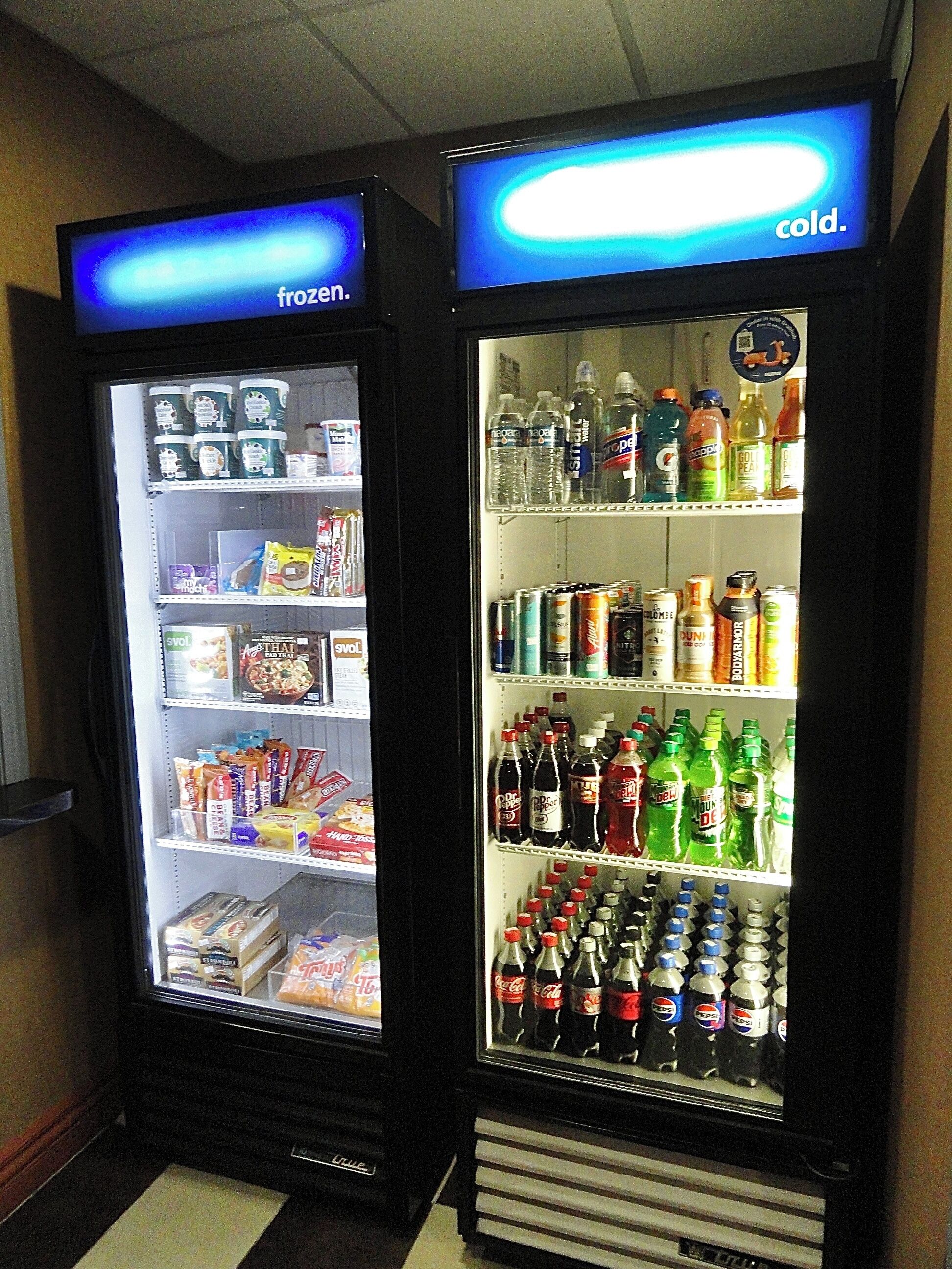 Deux distributeurs automatiques de boissons proposant une variété de boissons et d’en-cas.