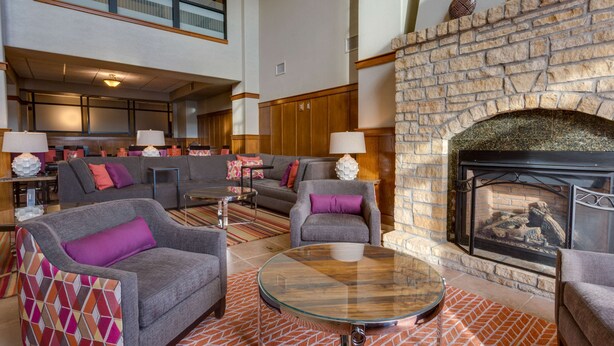 A lobby with a stone fireplace, sofas, and a glass coffee table. - Drury Inn & Suites Las Cruces (Las Cruces)