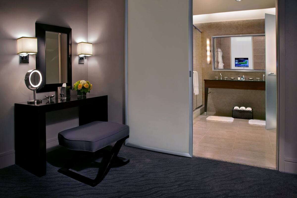 A modern bathroom with a vanity, mirror, and a digital display.