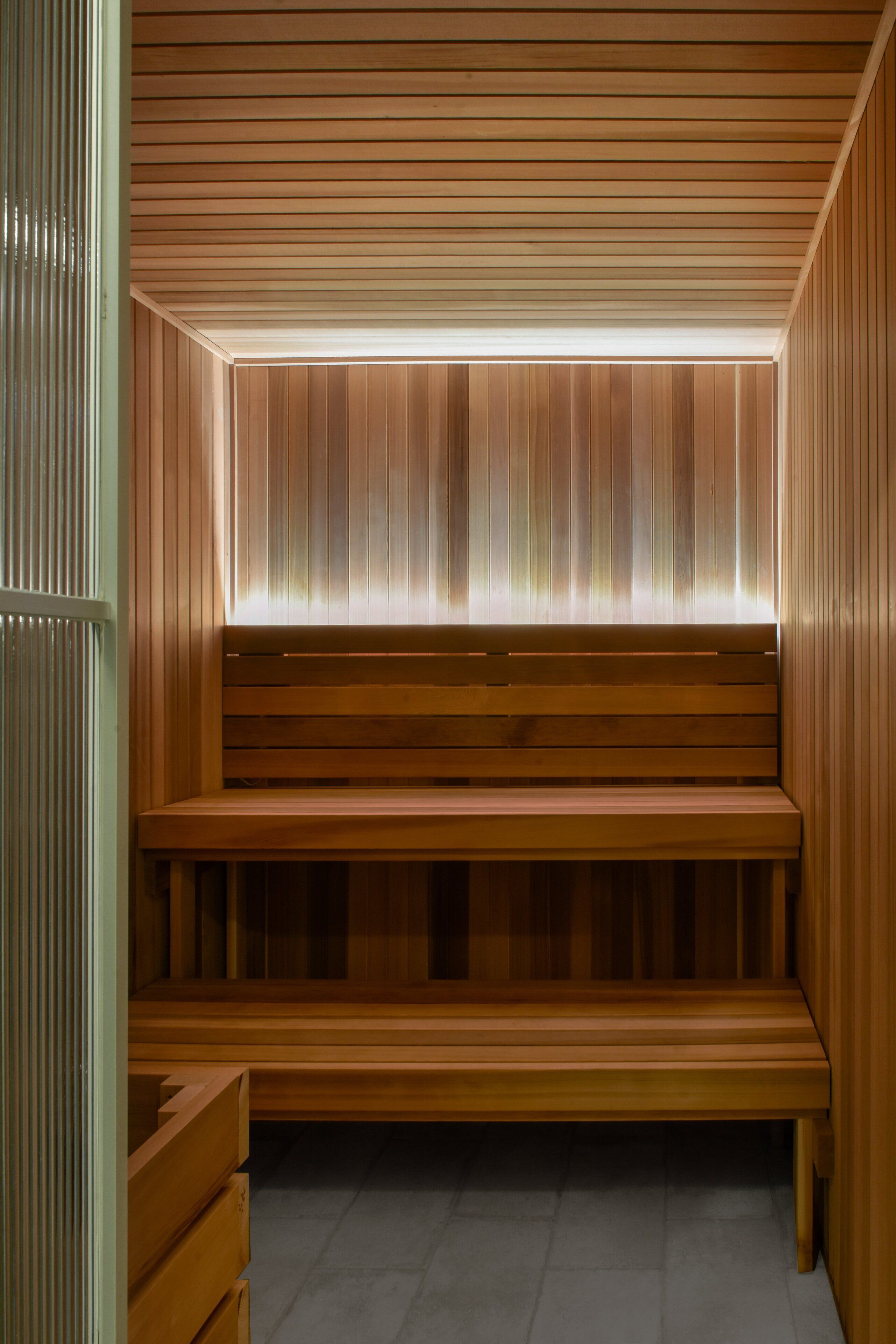 A wooden sauna with benches and a slatted ceiling.