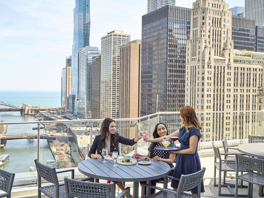 Terraza en la azotea con vista a la ciudad, una mesa redonda y sillas.