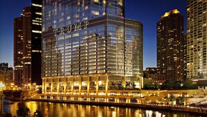 Un hotel de gran altura con un llamativo letrero 'TRUMP', reflejado en el agua, rodeado de otros edificios altos.
