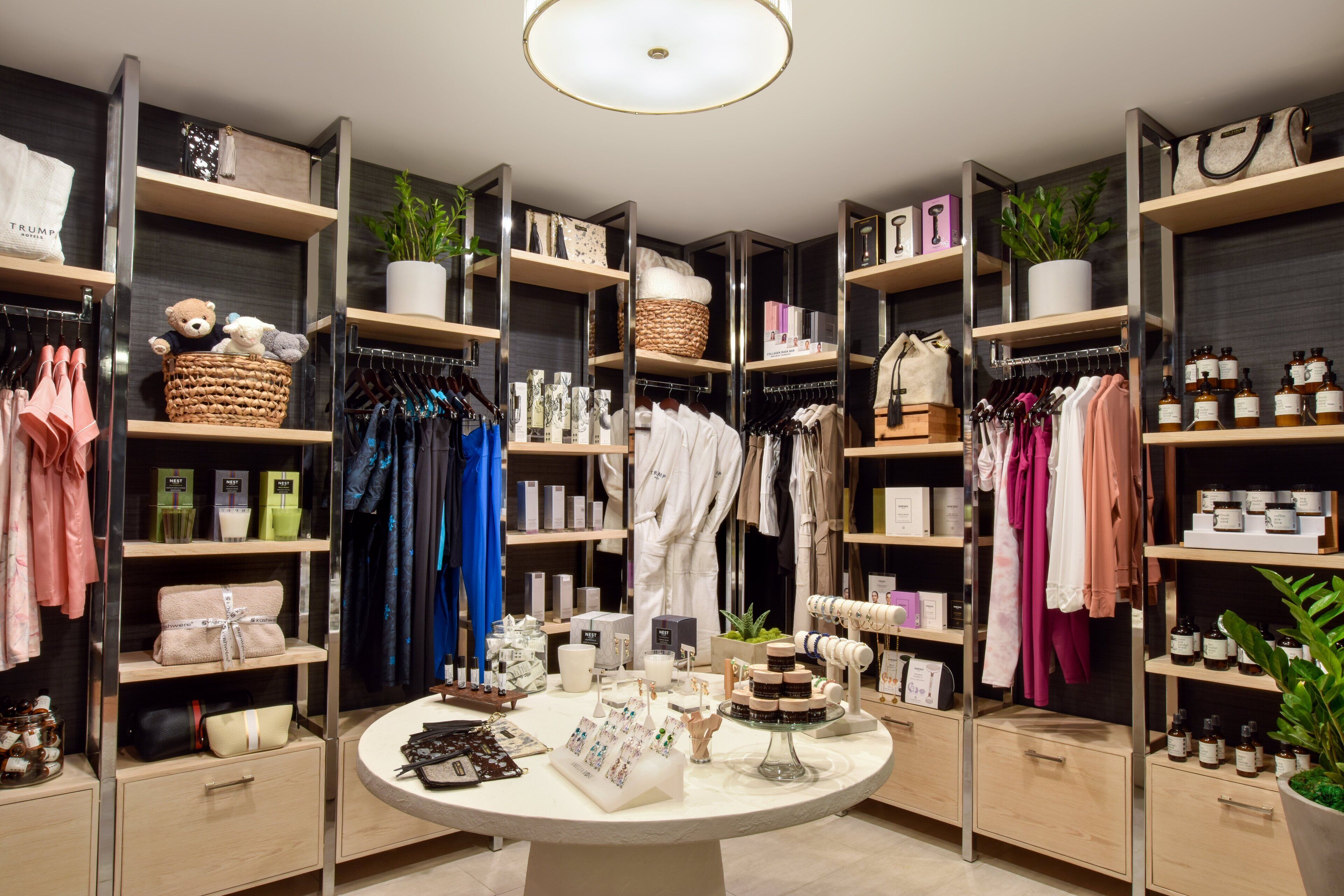 A well-organized boutique with shelves of clothing, accessories, and toiletries.
